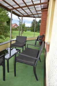 eine Terrasse mit 3 Stühlen und einem Tisch auf der Veranda in der Unterkunft Hotel La-Pergola in Kolkwitz