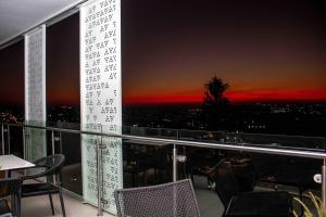 a balcony with a view of a city at night at Epic Getaway in Waterfall in Midrand