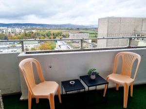 - un balcon avec vue doté de 2 chaises et d'une table dans l'établissement Main Apartments in Hattersheim, à Hattersheim am Main