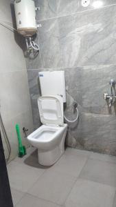 a bathroom with a white toilet in a room at Anant home stay in Ujjain