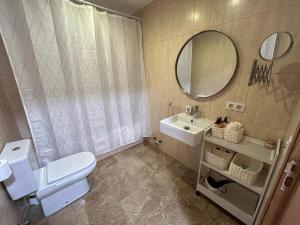 Un baño con inodoro, lavabo y espejo. en 20 Pasos, en Tudela