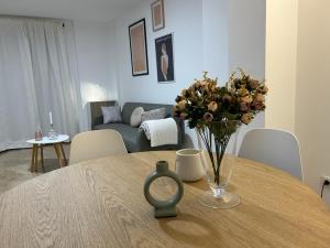 Un jarrón de flores sobre una mesa en una sala de estar. en 20 Pasos, en Tudela 6 fotos más