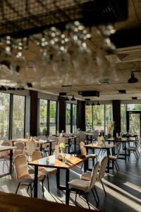 - une salle à manger avec des tables, des chaises et des fenêtres dans l'établissement Hotel Promenada Biznes & Wypoczynek, à Radom