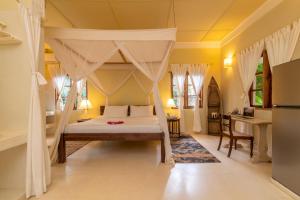 a bedroom with a bed with a canopy at Allamanda Villa by YourHost, 10 bedroom, Malindi in Malindi +69 photos