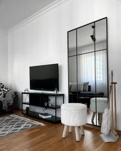 ein Wohnzimmer mit einem TV und einem Spiegel in der Unterkunft Bright Prishtina City Apartment in Pristina