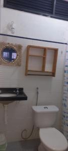 a bathroom with a white toilet and a sink at EDEN Pousada in Lagoinha