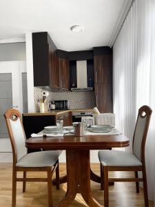 einen Esstisch mit 2 Stühlen und eine Küche in der Unterkunft Bright Prishtina City Apartment in Pristina