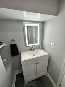 a white bathroom with a sink and a mirror at Downtown Delight in Heart of DC’s Bustling Streets in Washington