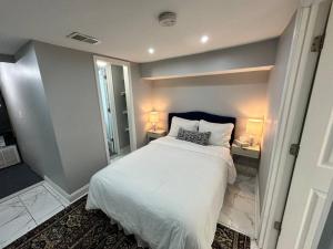 a bedroom with a white bed and a desk with two lamps at Downtown Delight in Heart of DC’s Bustling Streets in Washington, D.C.