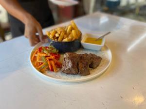a plate of food with meat and vegetables on a table at Apartamentos Los Telares in Hermigua