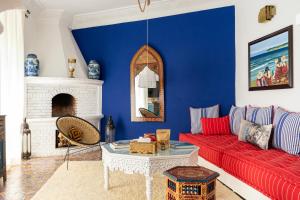 uma sala de estar com um sofá vermelho e uma parede azul em Lalla Soulika em Tânger