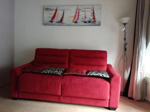 um sofá vermelho sentado numa sala de estar em Sam Le Lezard Sarl em Nice