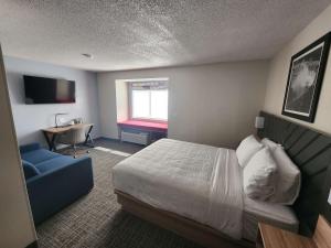 a hotel room with a bed and a desk at Eva Hotel Buffalo Airport, BW Signature Collection in Buffalo