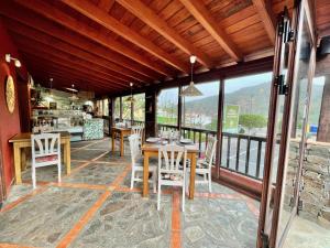a restaurant with tables and chairs on a balcony at Apartamentos Los Telares in Hermigua