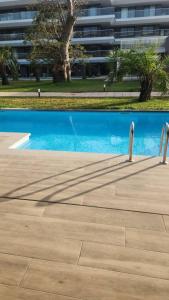 uma piscina azul com um edifício ao fundo em Costa Vista- Standard bedroom flat#501 with private pool- kololi sands em Sere Kunda