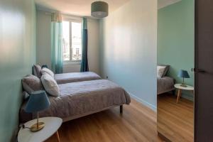 a bedroom with a bed and a table with a lamp at Chez Magali in Rouen +2 photos