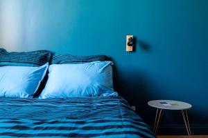 a blue bedroom with a bed and a blue wall at Chez Magali in Rouen