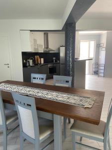 a dining room table with chairs and a kitchen at Villa Maduna 1 in Kaštel