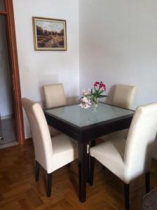 een eettafel met stoelen en een vaas met bloemen bij Apartment Biserka in Cavtat