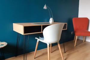 a desk with a white chair and a red chair at Chez Magali in Rouen