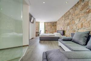 a living room with a couch and a stone wall at Luxury rooms Ana in the heart of Split in Split