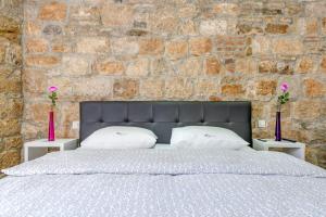 1 dormitorio con 1 cama grande y 2 jarrones en Luxury rooms Ana in the heart of Split, en Split