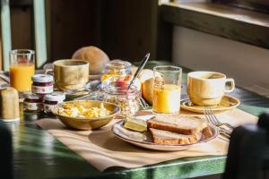 a table topped with plates of food and cups of orange juice at Haus am Berg - Pension direkt am Skihang in Kurort Oberwiesenthal