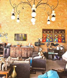 a living room with two couches and a brick wall at Lá em Casa - Guest House in Barra Grande