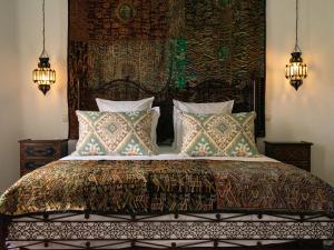una camera da letto con un grande letto con cuscini di Lalla Soulika a Tangeri