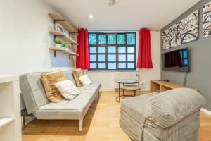 Modern flat in PRIME LOCATION near Shoreditch & Brick lane في لندن: غرفة معيشة مع أريكة وطاولة