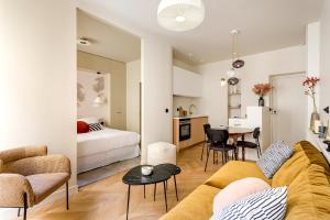 een woonkamer met een bank en een slaapkamer bij Lune Montorgueil in Parijs