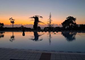 a pool of water with a sunset in the background at Domaine Bordaberry T2 Jardin et Superbe piscine in Urrugne