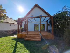 une petite maison avec une terrasse couverte et une terrasse dans l'établissement Iluska Vendégház, à Mátraszentimre