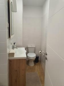 een witte badkamer met een toilet en een wastafel bij Zabava Sacavém in Sacavém