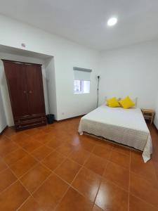 a bedroom with a bed with yellow pillows on it at Zabava Sacavém in Sacavém