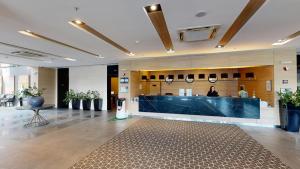 a lobby with a counter and a person in the background at Best Western Premier Sofia Airport Hotel in Sofia