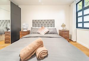 Modern flat in PRIME LOCATION near Shoreditch & Brick lane في لندن: غرفة نوم بسرير كبير عليها بطانية