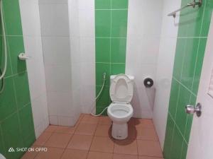 ein Bad mit einem WC in einer grünen und weißen Kabine in der Unterkunft Bumnsaya Place บุญสะญา เพลส in Ban Nong Samet