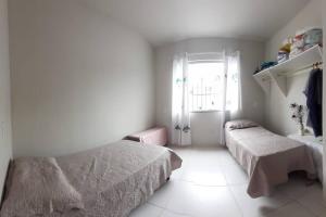 a bedroom with two beds and a window at Residencial Casa Grande- Apto 01 in Santa Cruz Cabrália
