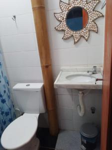 a bathroom with a toilet and a sink and a mirror at EDEN Pousada in Lagoinha