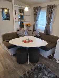 a living room with a table and a couch at 8 berth caravan Turnberry Holiday Park in Turnberry