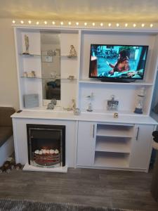 a living room with a tv and a fireplace at 8 berth caravan Turnberry Holiday Park in Turnberry
