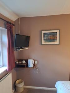 una camera da letto con TV a schermo piatto a parete di The Prince of Wales a Huntingdon