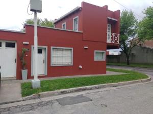 a red house on the side of a street at DEPARTAMENTO UMARDA in Tandil