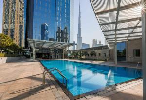 a large swimming pool in a city with tall buildings at Central Park Towers, City View - DIFC - Mint Stay in Dubai