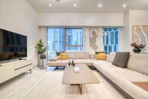 a living room with a large couch and a tv at Central Park Towers, City View - DIFC - Mint Stay in Dubai
