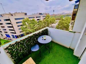 una pequeña mesa azul en un balcón con césped verde en Apartamento Daniel Zaragoza, en Zaragoza