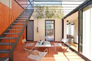 バルセロナにあるDestinationBCN Urgell Apartmentのテーブルと椅子、階段が備わる客室です。
