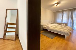 a bedroom with a bed and a mirror at Mountain Escape Loft in Buşteni