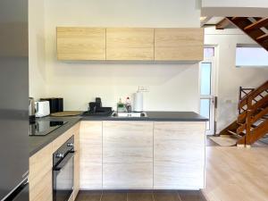 a kitchen with wooden cabinets and a sink at Alpine Cottage w. Mountain View in Buşteni